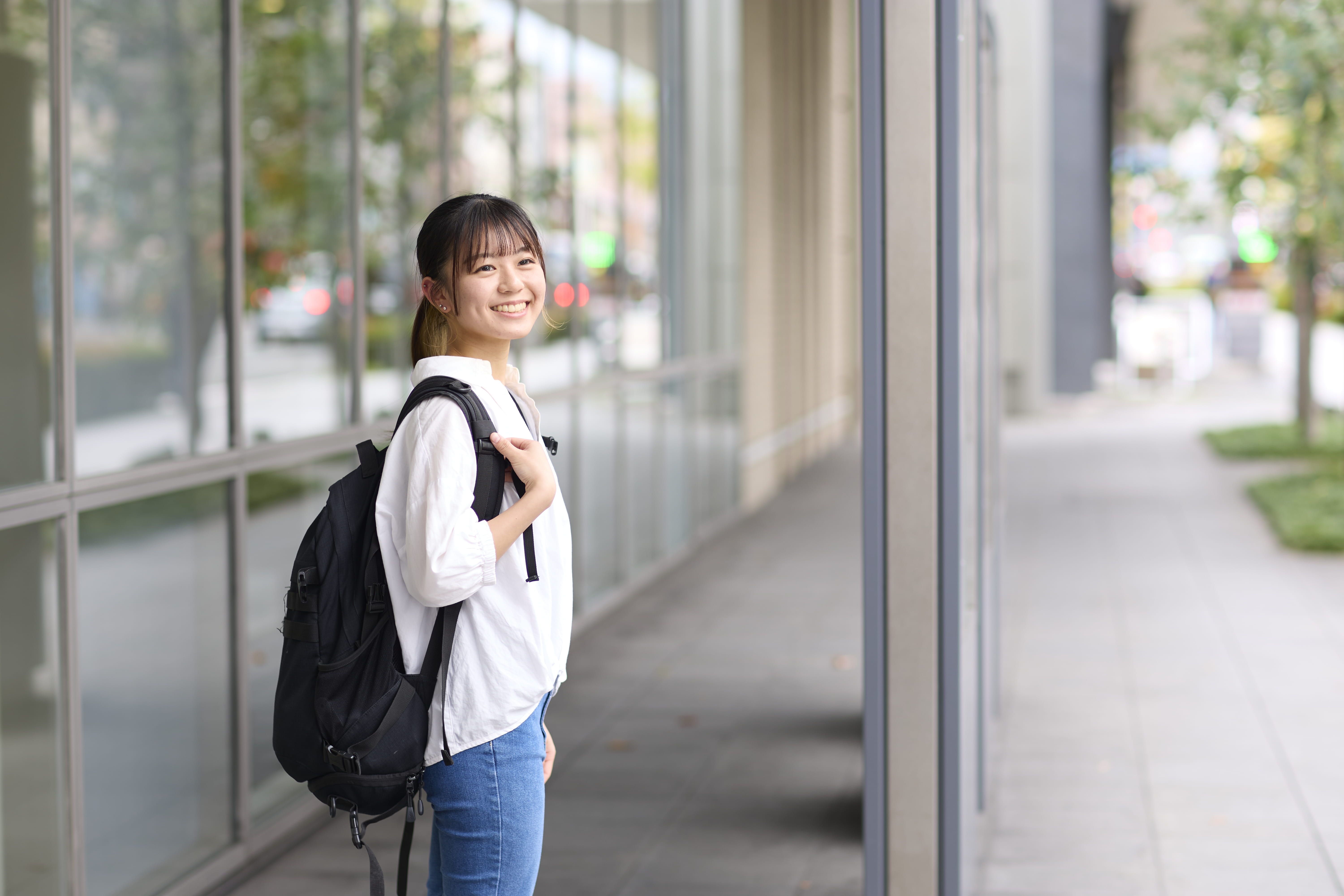 二条キャンパス付近で笑顔を見せる女子学生の様子