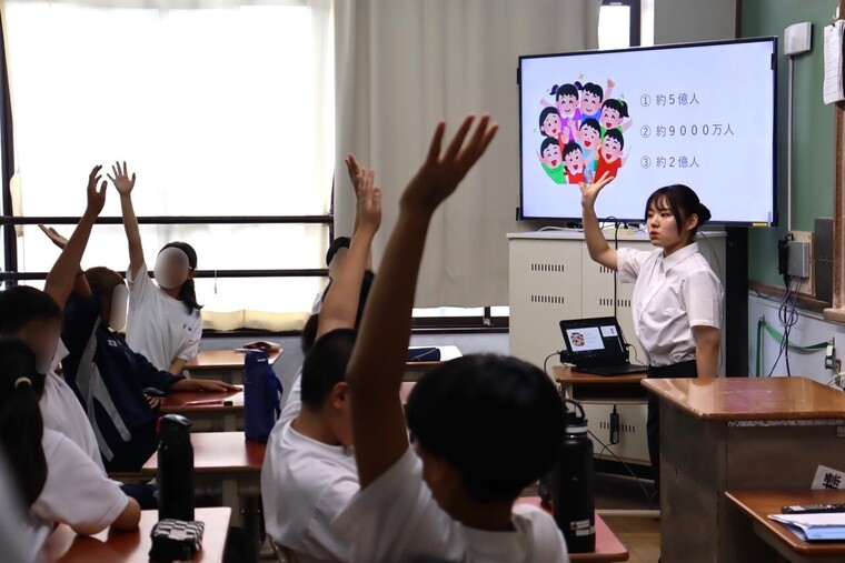 大学生の問いかけに手を挙げる中学生たち